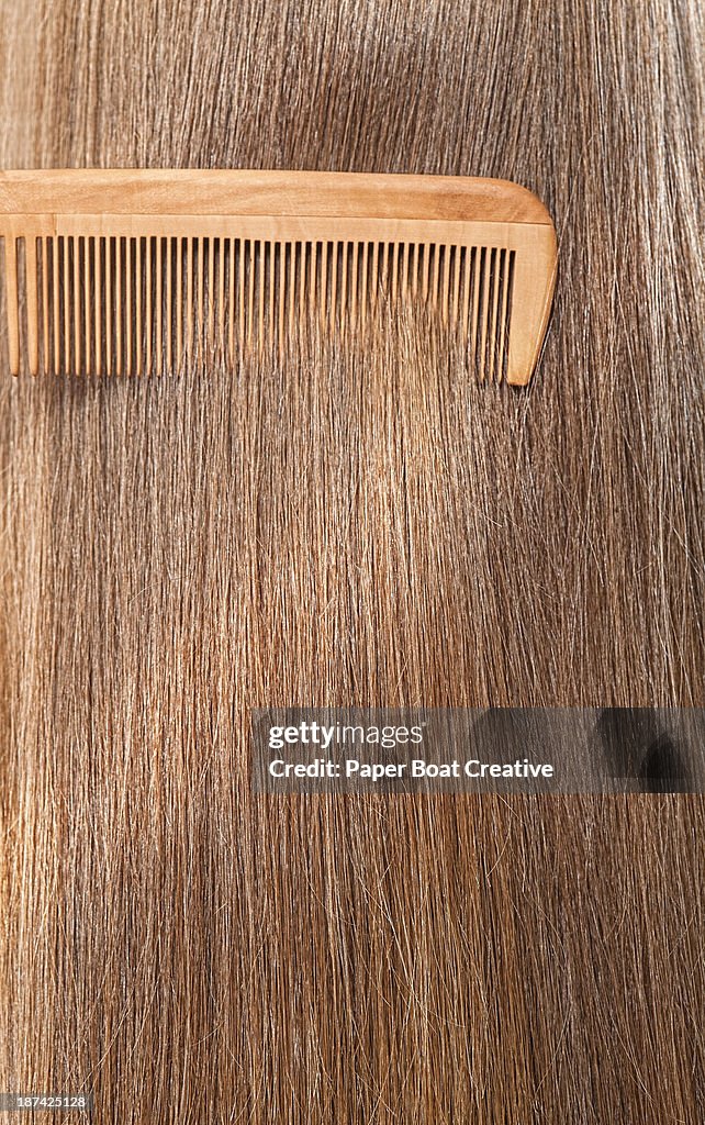 Close up straight brunette hair being combed