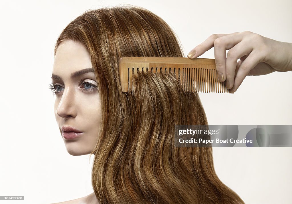 Lady with her red hair being combed