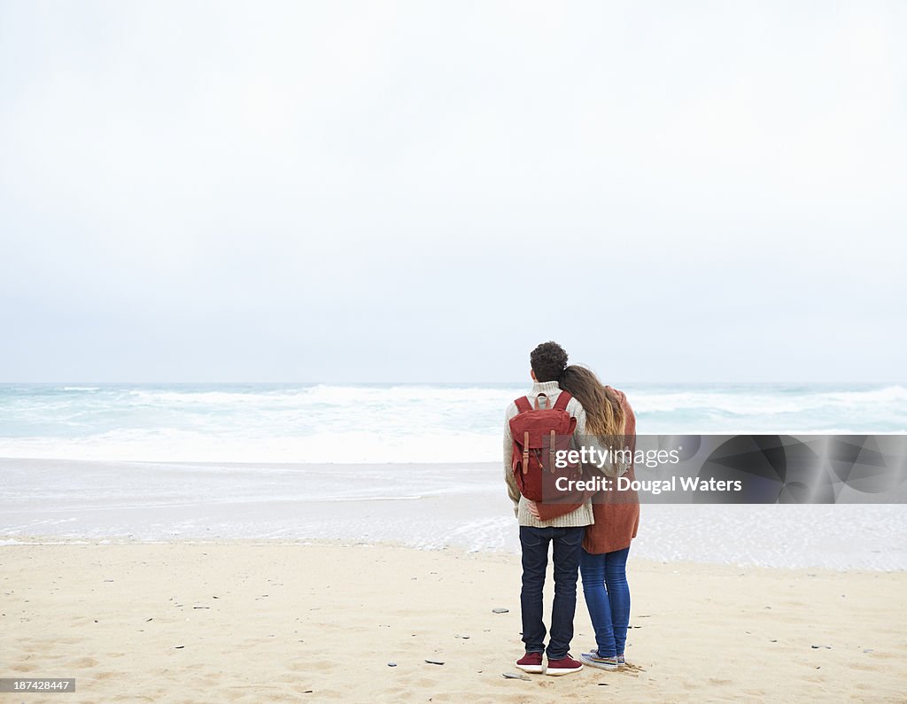 Couple embracing on beach.