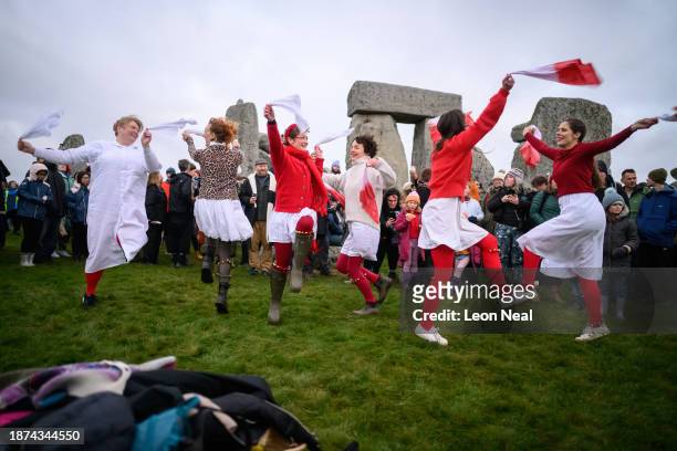 Traditional dance group performs near to the standing stones at Stonehenge before sunrise on Winter Solstice on December 22, 2023 in Wiltshire,...