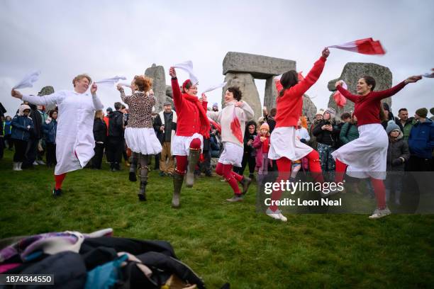 Traditional dance group performs near to the standing stones at Stonehenge before sunrise on Winter Solstice on December 22, 2023 in Wiltshire,...