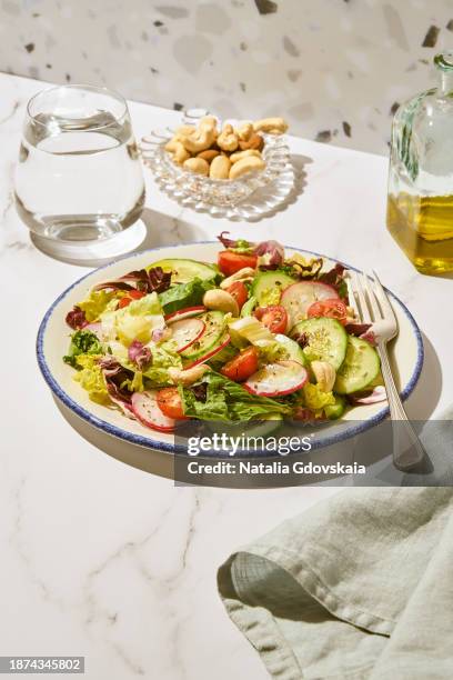 vegan vegetarian salad - cherry tomato, cucumber, radish, lettuce - cashew pieces stock pictures, royalty-free photos & images