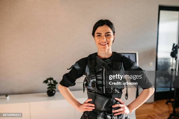 young woman wearing an ems suit in the gym - ems stockfoto's en -beelden