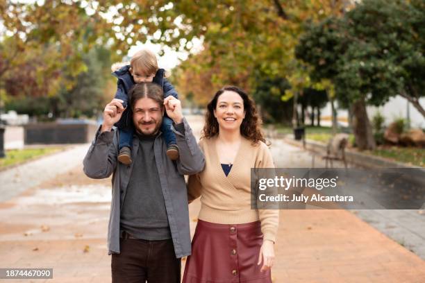 padre di 40 anni che porta il figlio di 1 anno in un giorno d'autunno, in posa con la madre - older mother baby 40 years foto e immagini stock