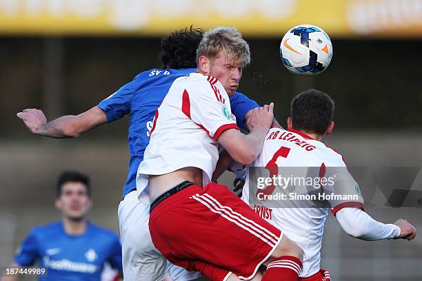 Fabian Franke jumps for a header with team-mate Henrik Ernst of Leipzig and Dominik Stroh-Engel of Darmstadt during the Third Bundesliga match...