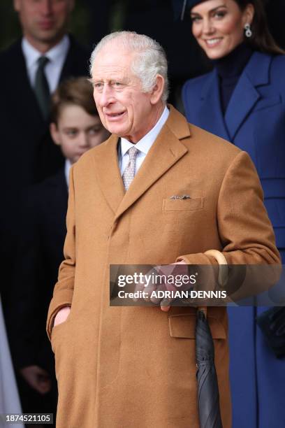 Britain's King Charles III waits on the church steps after attending the Royal Family's traditional Christmas Day service at St Mary Magdalene Church...