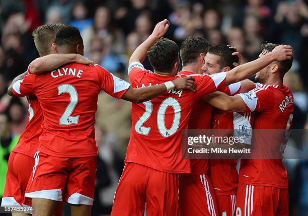 Morgan Schneiderlin of Southampton is congratulated by team mates as he scores their first goal during the Barclays Premier League match between...