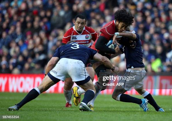 Ryu Koliniasi Holani of Japan is tackled by Ruaridh Jackson and Euan