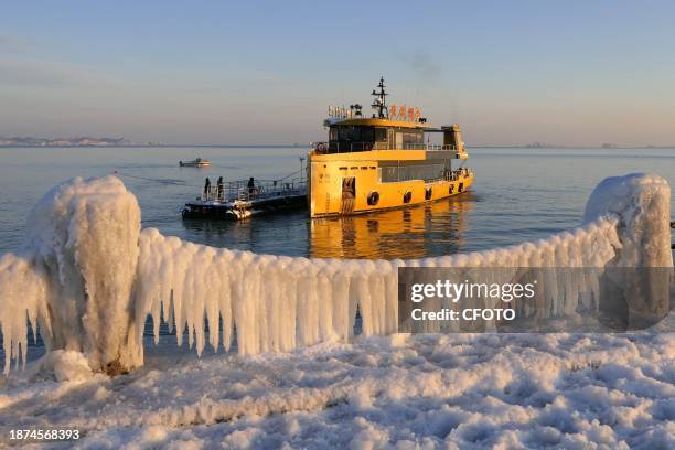 Sea waves condense into ice to cover a guardrail along the beach in Yantai, East China's Shandong province, Dec 23, 2023.
