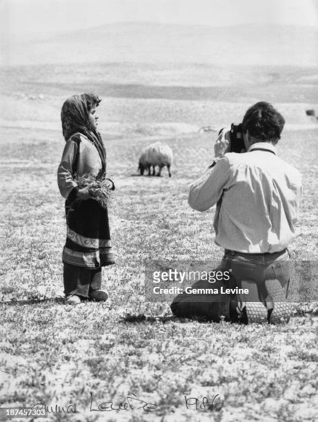 Antony Armstrong-Jones, 1st Earl of Snowdon, photographs a young girl in the countryside in Israel, circa 1986.