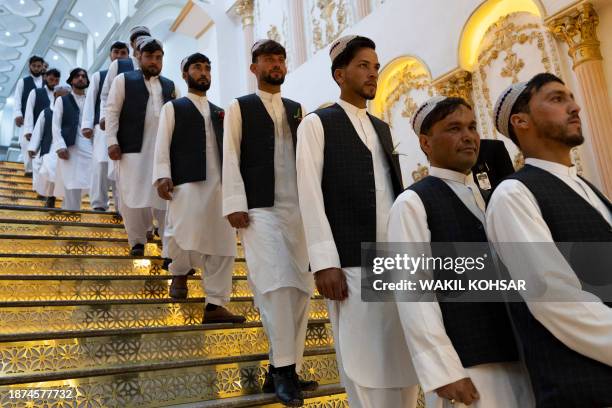 Afghan grooms arrive during a mass wedding ceremony at a wedding hall in Kabul on December 25, 2023. Fifty couples married on December 25 in a joint...