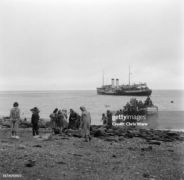 Passengers disembarking at the landing beach after travelling on the Bristol Queen from Bristol to the island of Lundy, Devon, August 1954. Earlier...