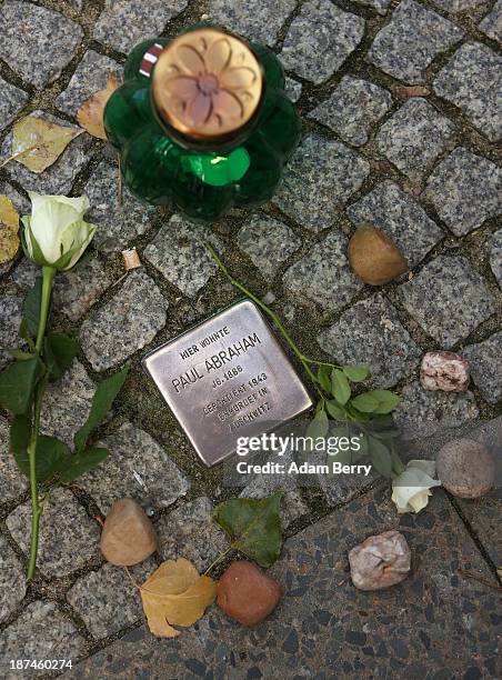 Rose, candle and pebbles lie next to a 'Stolperstein' or Stumbling Block, small cobblestone-sized plaques by artist Gunter Demnig dedicated to the...