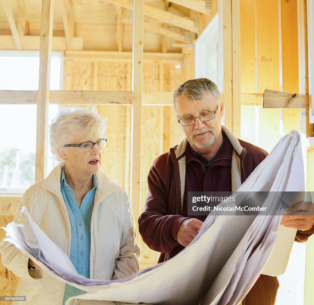 Senior couple discussing the plans of their new home