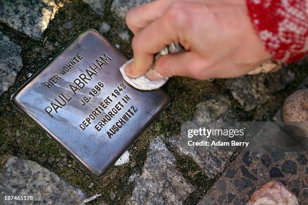 Local resident polishes a 'Stolperstein', or Stumbling Block, one of thousands of small cobblestone-sized plaques by artist Gunter Demnig dedicated...