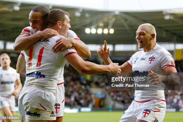Brett Ferres of England celebrates his try with team mates Leroy Cudjoe and Ryan Hall during the Rugby League World Cup Group A match at the KC...