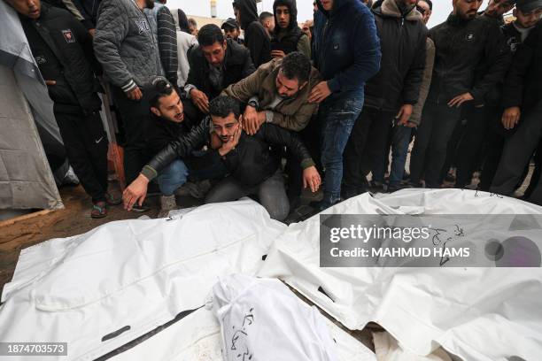 Palestinian mourns relatives, killed in an overnight Israeli strike on the Al-Maghazi refugee camp, during a mass funeral at the Al-Aqsa hospital in...
