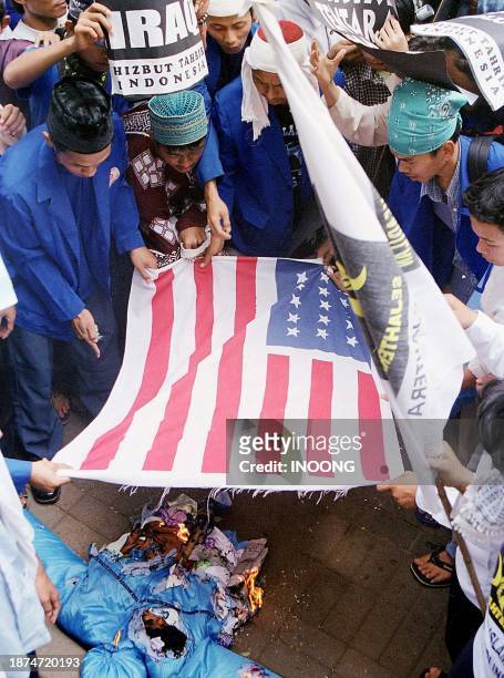 Demonstrators prepare to burn a US flag during a rally in Tangerang district, Banten province, to protest against the US-led war on Iraq, 06 April...