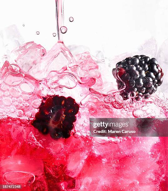 berry spritzer pouring over ice with blackberries - fruta baya fotografías e imágenes de stock