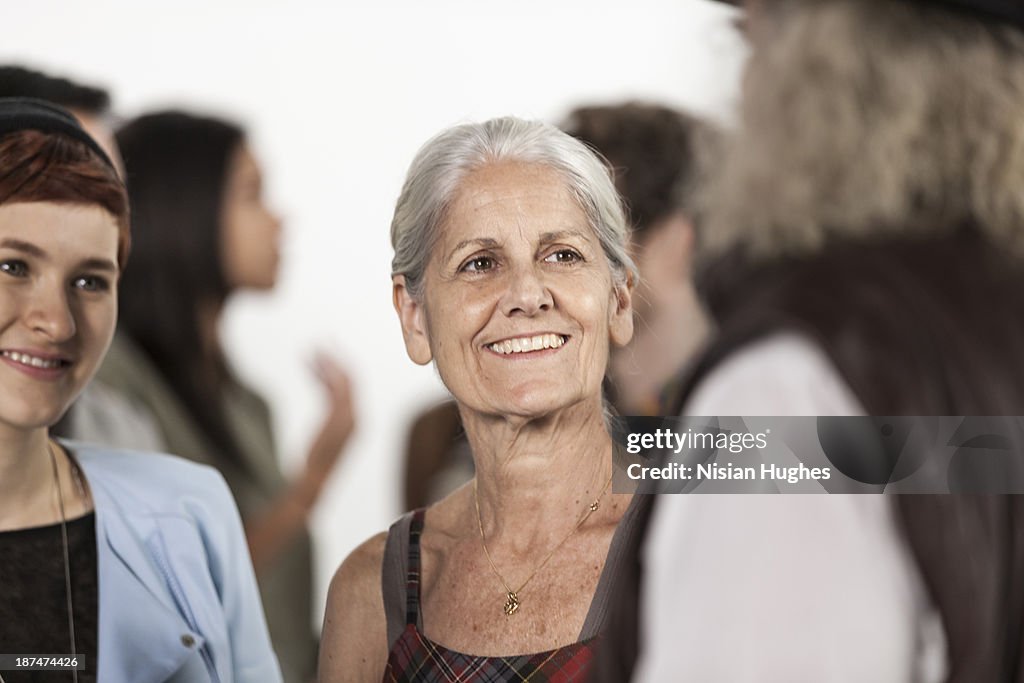 Older woman standing in crowd of people