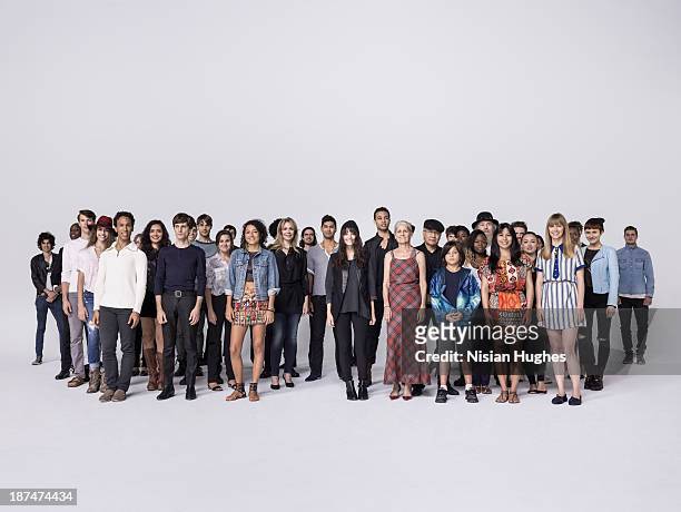 large group of people standing together in studio - menschengruppe stock-fotos und bilder