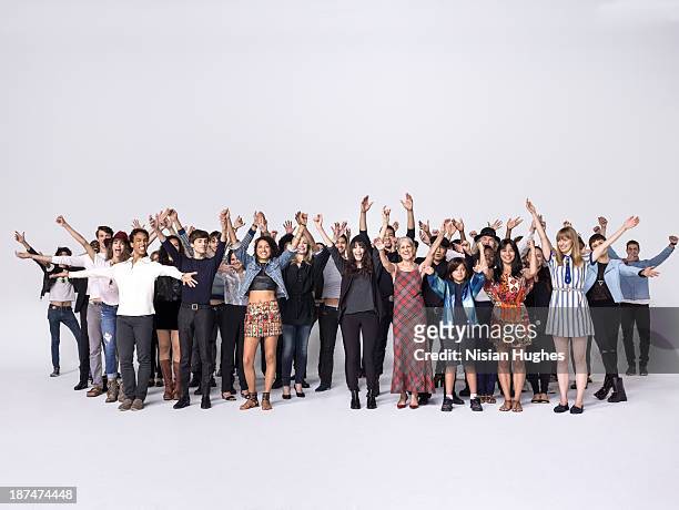 large group of people with raised hands - arms raised stock-fotos und bilder