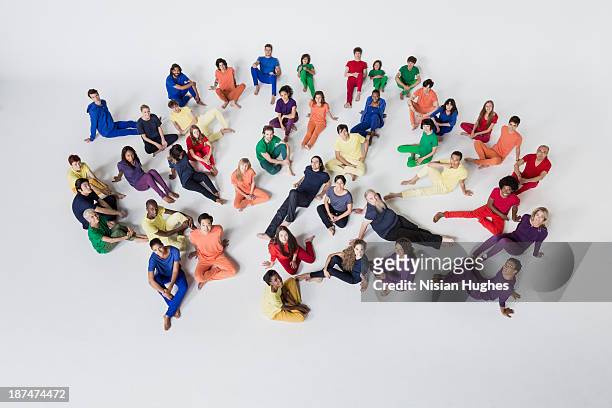 diverse group of people reclining on studio floor - elevated view of person on white background stock pictures, royalty-free photos & images