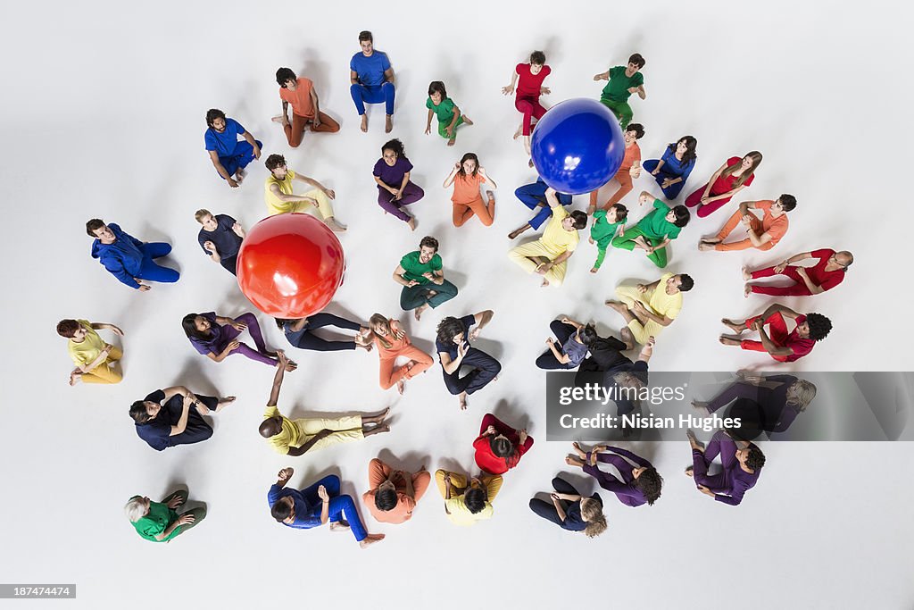Diverse Group of People Tossing Blue and Red Balls