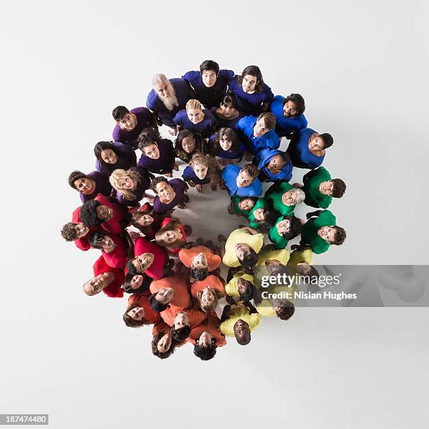 people in a circle looking up and smiling - rainbow kids stock-fotos und bilder