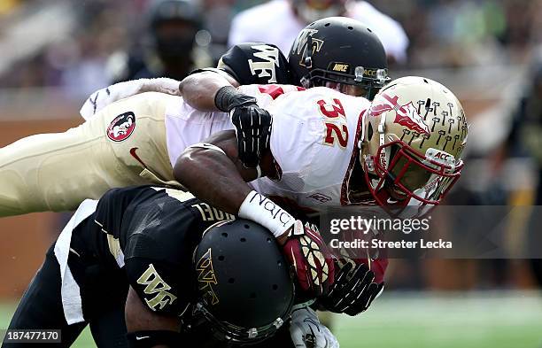 James Wilder Jr. #32 of the Florida State Seminoles tries to get away from teammates Merrill Noel and Anthony Wooding Jr. #11 of the Wake Forest...