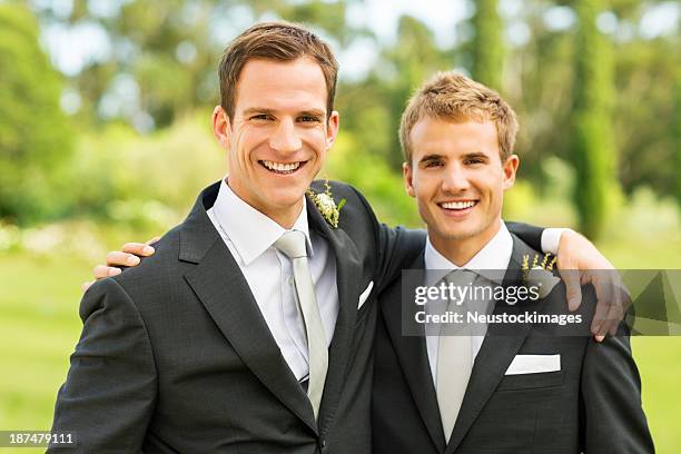 best man and groom standing together in garden - best man stock pictures, royalty-free photos & images
