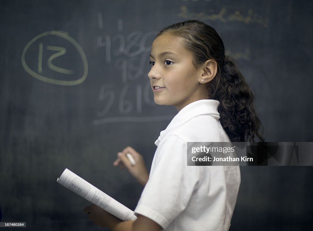 Fifth grade girl at chalk board.