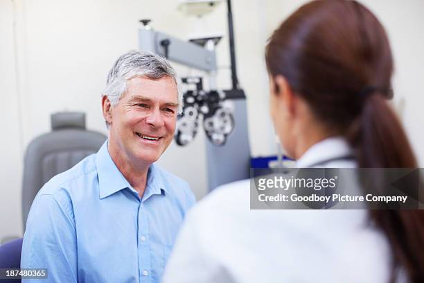building a relationship between doctor and patient - smiling mature eyes stockfoto's en -beelden