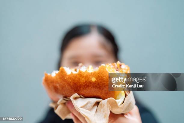 cropped shot of lovely little asian girl having burger in restaurant. eating out lifestyle. - little burger stock pictures, royalty-free photos & images