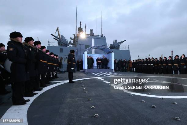 This pool photograph distributed by Russian state agency Sputnik, shows Russia's President Vladimir Putin attends a flag-raising ceremony on the...