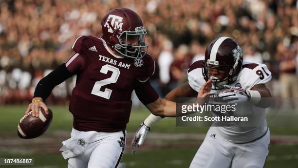Johnny Manziel of the Texas A&M Aggies fights off the tackle of Preston Smith of the Mississippi State Bulldogs at Kyle Field on November 9, 2013 in...