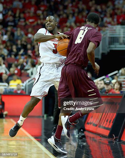 Chris Jones of the Louisville Cardinals and Joe Chealey of the College of Charleston Cougars batle for a loose ball during the game at KFC YUM!...