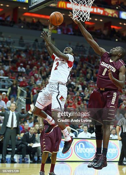 Russ Smith of the Louisville Cardinals shoots the ball while defended by Adjehi Baru of the College of Charleston Cougars batle for a loose ball...