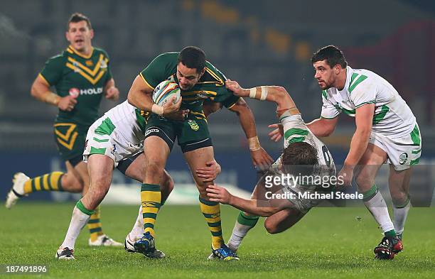 Jarryd Hayne of Australia charges through Tyrone McCarthy and Rory Kostjasyn of Ireland during the Rugby League World Cup Group A match between...