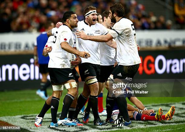 Liam Messam, Kieran Read and Sam Whitelock celebrate Charles Piutau's try during the international test match between France and the New Zealand All...