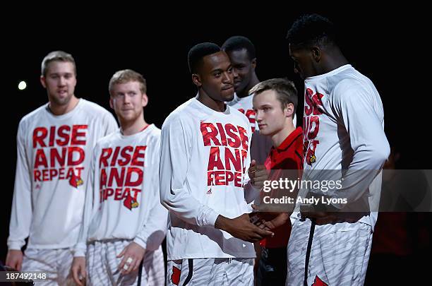 Kevin Ware shakes hands with Montrezl Harrell of the Louisville Cardinals as the players were introduced before the game against the College of...