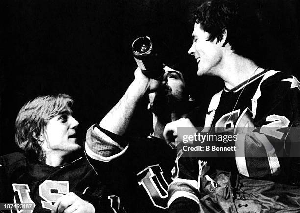 Neal Broten, goalie Jim Craig and John Harrington of the 1980 US Olympic hockey team pass around a bottle of champagne after winning the gold medal...