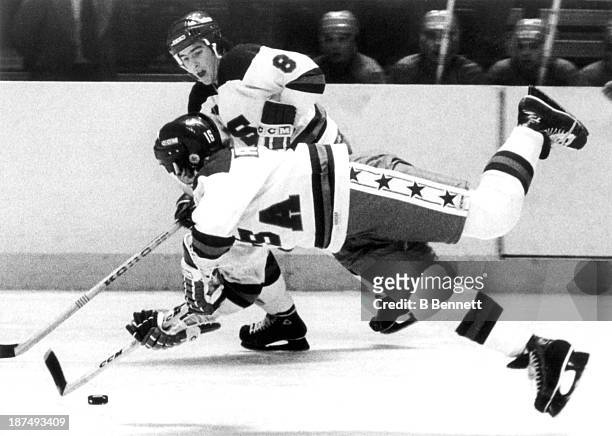 Mark Pavelich of Team USA trips as he passes the puck to his teammate Dave Silk during an 1980 exhibition game against the Soviet Union on February...