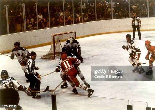 Yuri Lebedev of the Soviet Union chases the puck after the face-off against Mark Wells of Team USA during the semi-final Men's Ice Hockey event at...