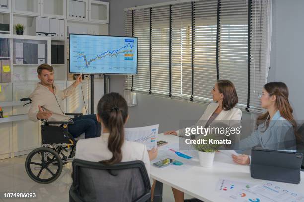 disabled businessman giving presentation to colleagues in meeting room. - inclusion body stockfoto's en -beelden