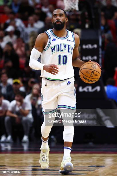 Mike Conley of the Minnesota Timberwolves dribbles the ball against the Miami Heat during the first quarter at Kaseya Center on December 18, 2023 in...