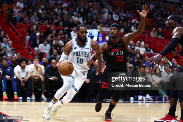 Mike Conley of the Minnesota Timberwolves drives against Jimmy Butler of the Miami Heat during the first quarter of the game at Kaseya Center on...