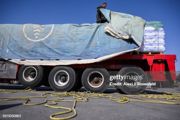 An Egyptian truck driver removes a tarp covering humanitarian aid after before being checked on it's way to Gaza at the Kerem Shalom Crossing after...