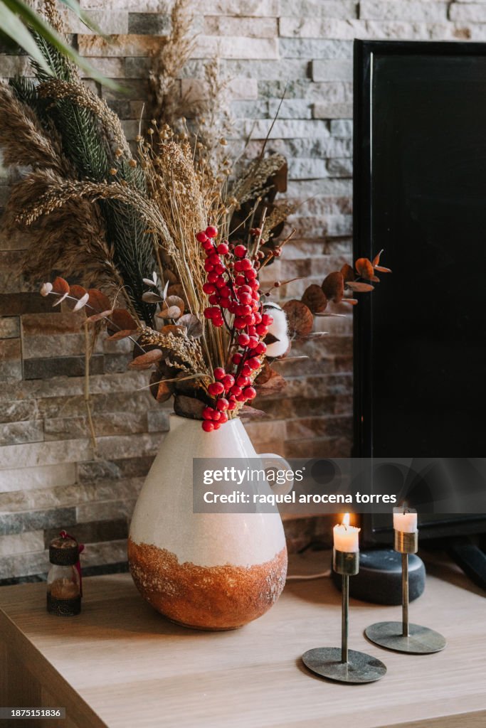 Candles and vase with dried flowers and Christmas decoration