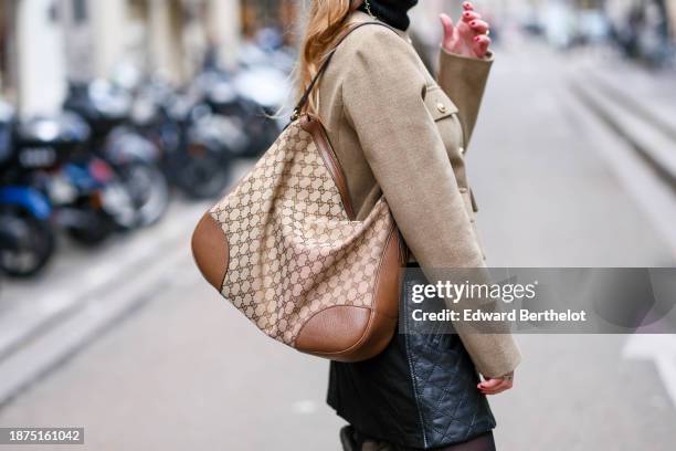 Maria Rosaria Rizzo wears a brown and beige large monogram / logo printed Gucci bag, a black quilted leather mini skirt,, during a street style...